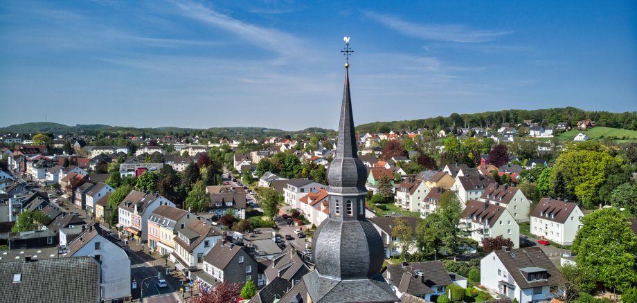 Die Zwiebelturmkirche in Niedersprockhövel mit der dahinterliegenden Landschaft 