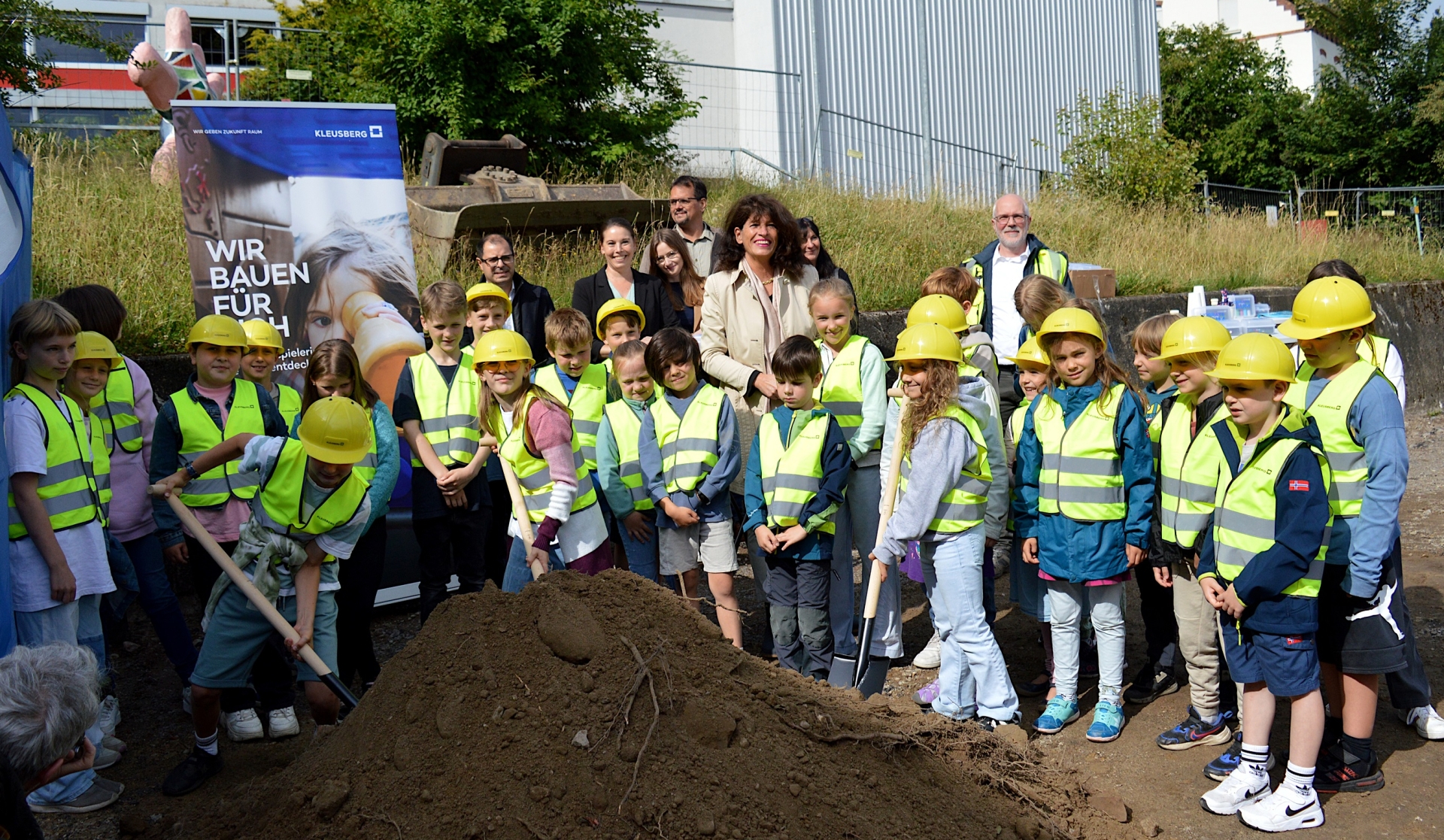 Die Kinder der Kindervertretung aller 17 Klassen der Grundschule Börgersbruch zusammen mit (v.l.) Renato Spocchia (Zentrale Gebäudebewirtschaftung), Patricia Petig-Büskens (Sachgebiet Schulen der Stadtverwaltung), Carina Stirn (Fachbereichsleiterin Bürgerschaftsservice und Bildung), Markus Muckenhaupt (Muckenhaupt Planung + Architektur), Bürgermeisterin Sabine Noll, Claudia Freise (Sachgebiet Schulen) und Erik Sabranski (Projektleitung Kleusberg GmbH und Co.KG)