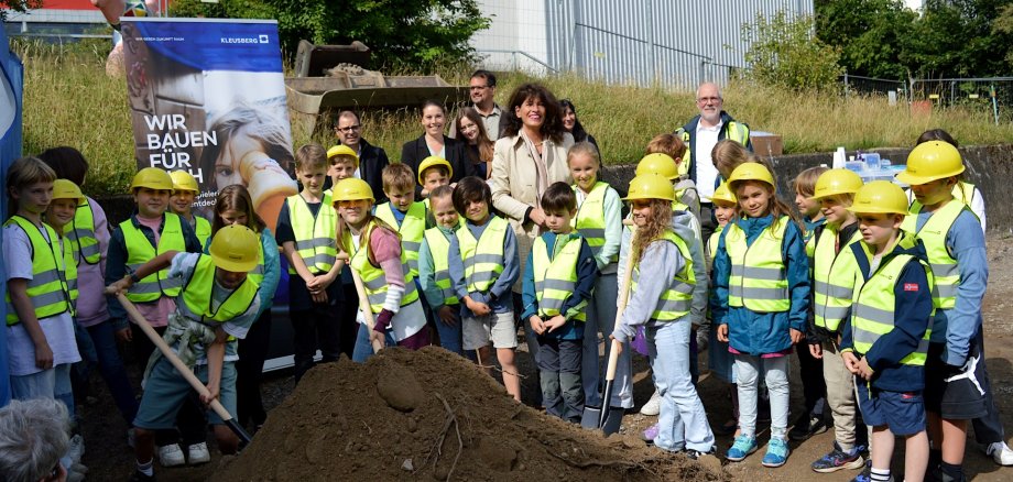 Die Kinder der Kindervertretung aller 17 Klassen der Grundschule Börgersbruch zusammen mit (v.l.) Renato Spocchia (Zentrale Gebäudebewirtschaftung), Patricia Petig-Büskens (Sachgebiet Schulen der Stadtverwaltung), Carina Stirn (Fachbereichsleiterin Bürgerschaftsservice und Bildung), Markus Muckenhaupt (Muckenhaupt Planung + Architektur), Bürgermeisterin Sabine Noll, Claudia Freise (Sachgebiet Schulen) und Erik Sabranski (Projektleitung Kleusberg GmbH und Co.KG)