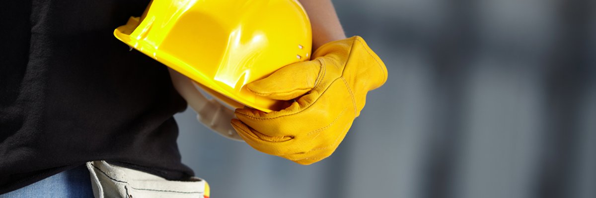 Bauarbeiter/in Bauarbeiter/in trägt Helm unterm Arm