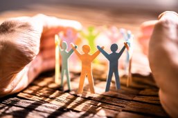 Ehrenamtliches Engagement Ausgeschnittene Papiermännchen halten sich an den Händen