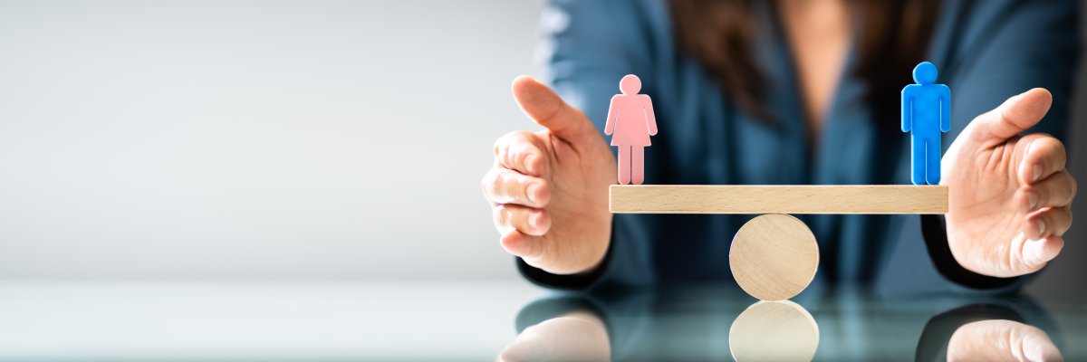 Gleichstellung Ausgeglichene Waage mit einer weiblichen und einer männlichen Holzpuppe