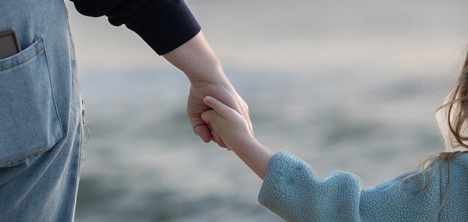 Hand in Hand Eine Mutter hält ihr Kind bei der Hand