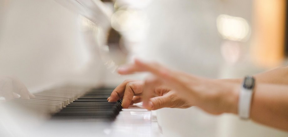 Hände, die auf einer Klaviatur liegen.