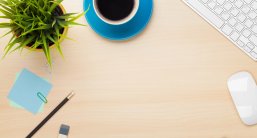 Schreibtisch Bürotisch mit Kaffeetasse, Computer und Blume