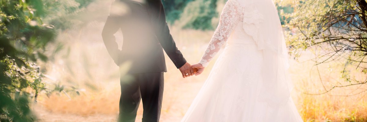 PantherMedia 27617541 Ein frisch verheiratetest Pärchen auf einer spätsommerlichen Wiese.