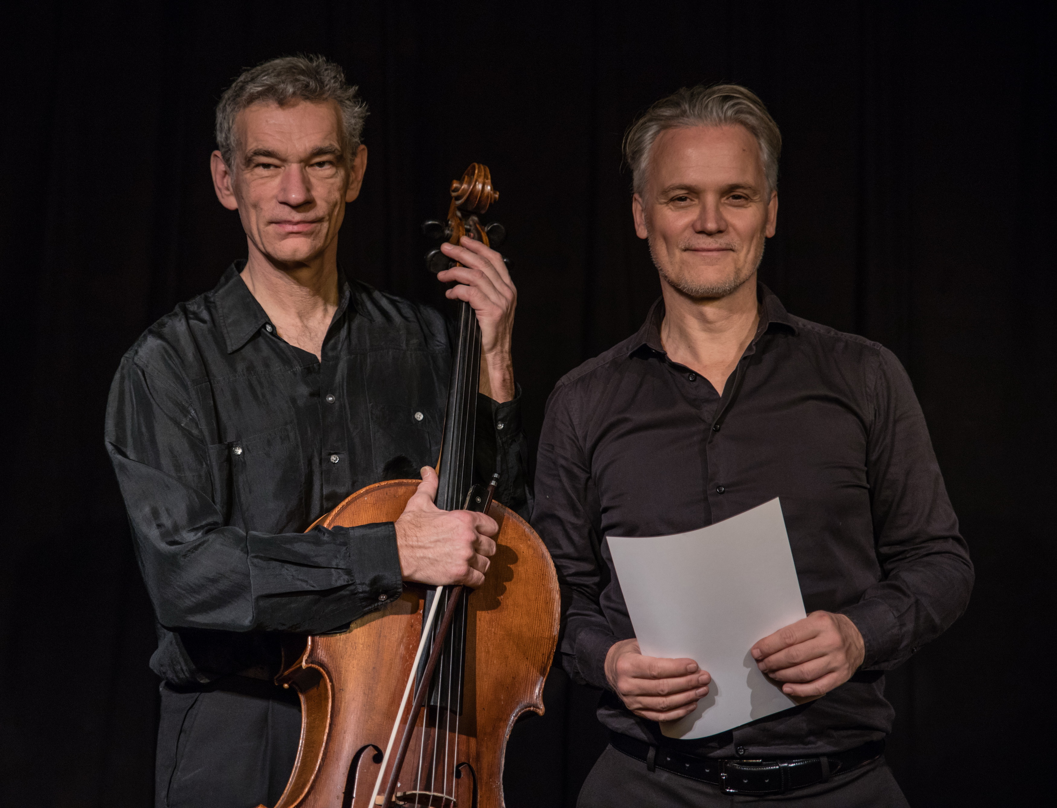 Zwei Männer, einer mit Cello, einer mit Buch